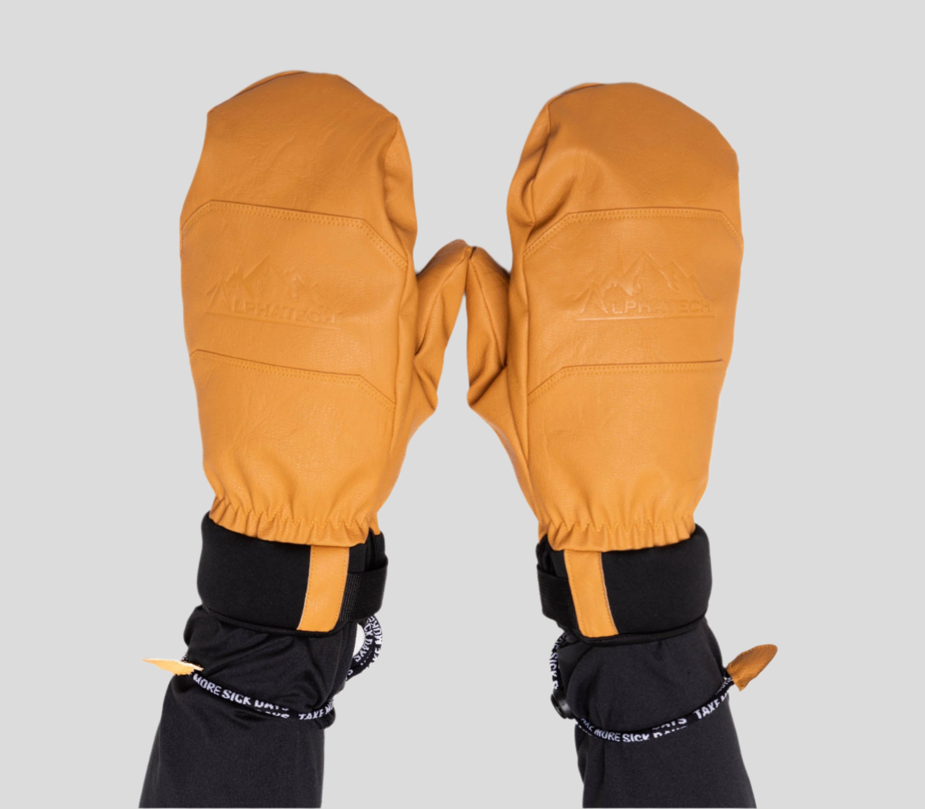 Pair of mustard yellow mittens with black cuffs on a white background